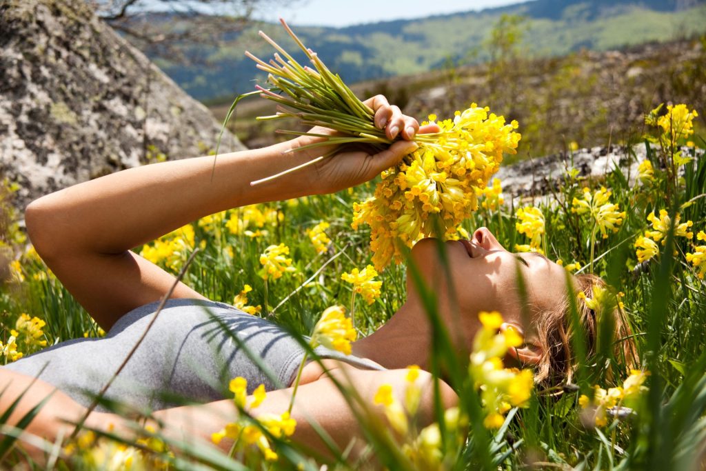 vrouw ruikt gele bloemen